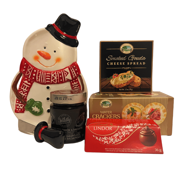 A beautifully arranged cheese board featuring an adorable snowman-shaped plate, a festive cheese knife, gourmet caramelized onion and balsamic vinegar preserve, smoked gouda cheese, water crackers, and Lindor milk chocolates.