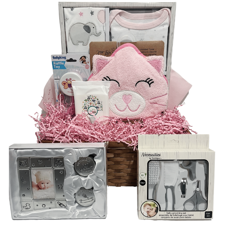 A pink gift basket containing a pink layette set, a hooded towel designed as a pink kitty, a rattle, keepsake set, grooming set, and baby wipes.