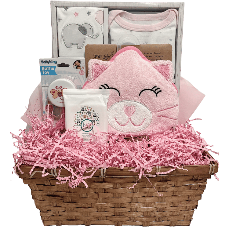 A pink gift basket containing a pink layette set, a hooded towel designed as a pink kitty, a rattle, and baby wipes.